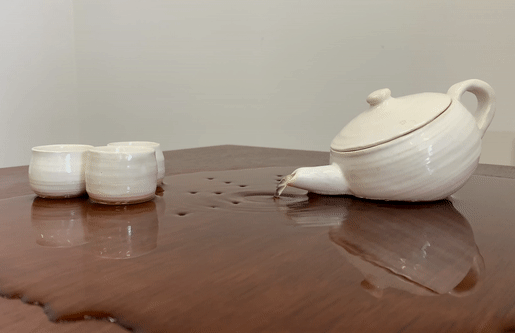 Teapot on table pouring water