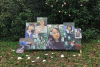 A group of portraits with sticky notes exhibit in the forest